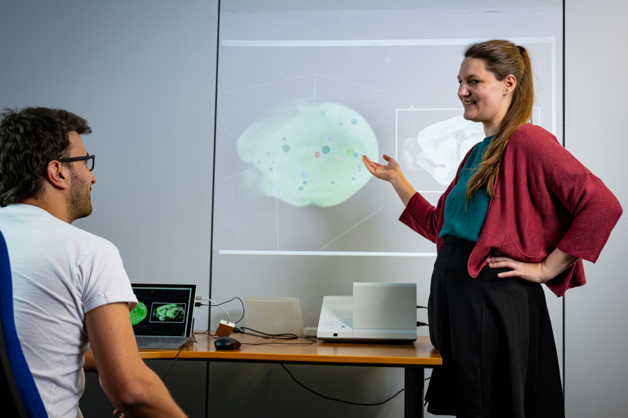 VRVis-Forscherin Sophia Ulonska präsentiert stehend die neurowissenschaftliche Anwendung BrainTrawler.